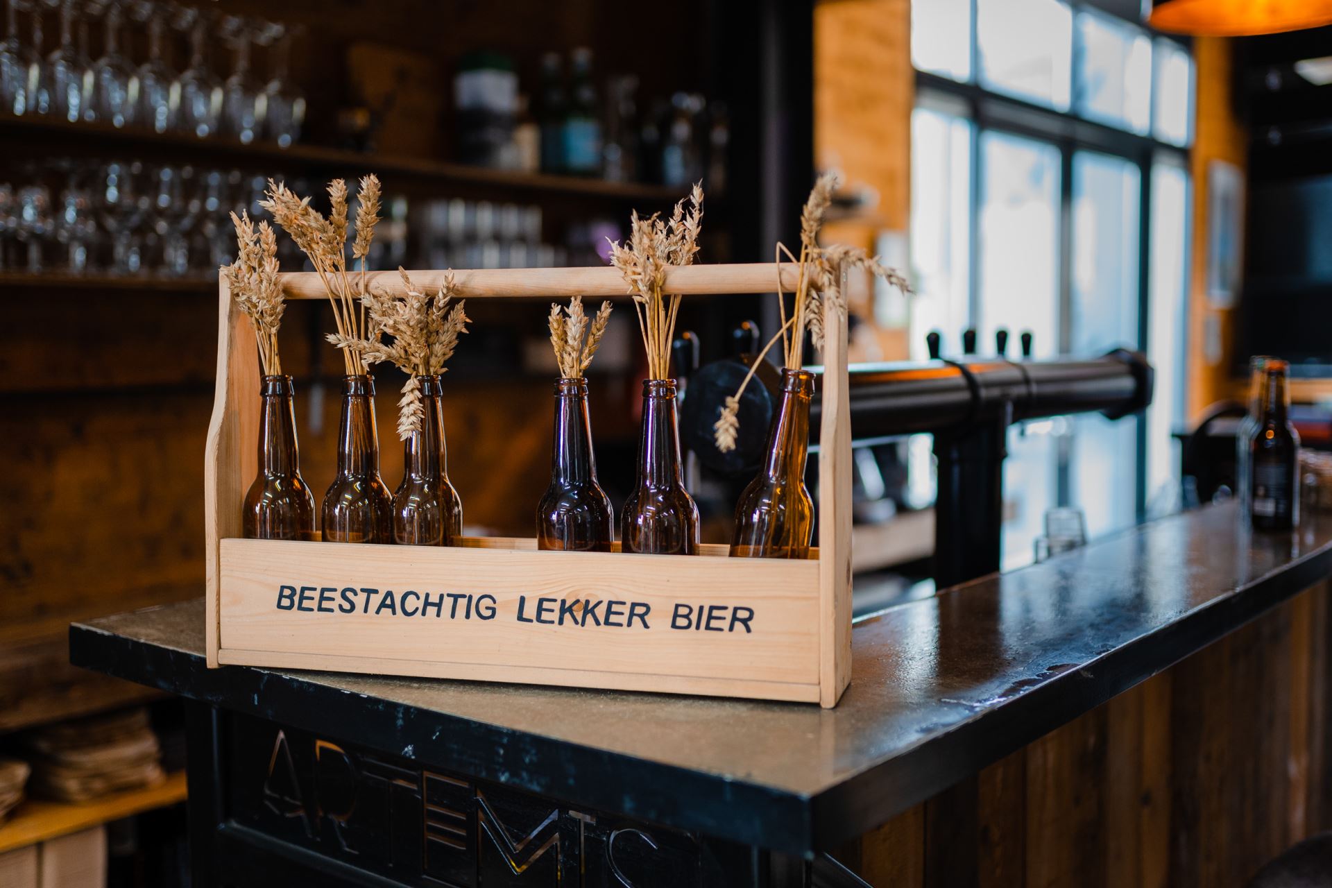 Bierflesjes in een houtenkist op een bar